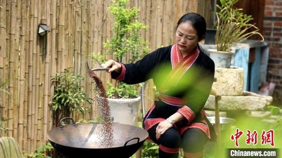  4月3日，谭芝祯在炒米做鲊肉。刘卓 摄